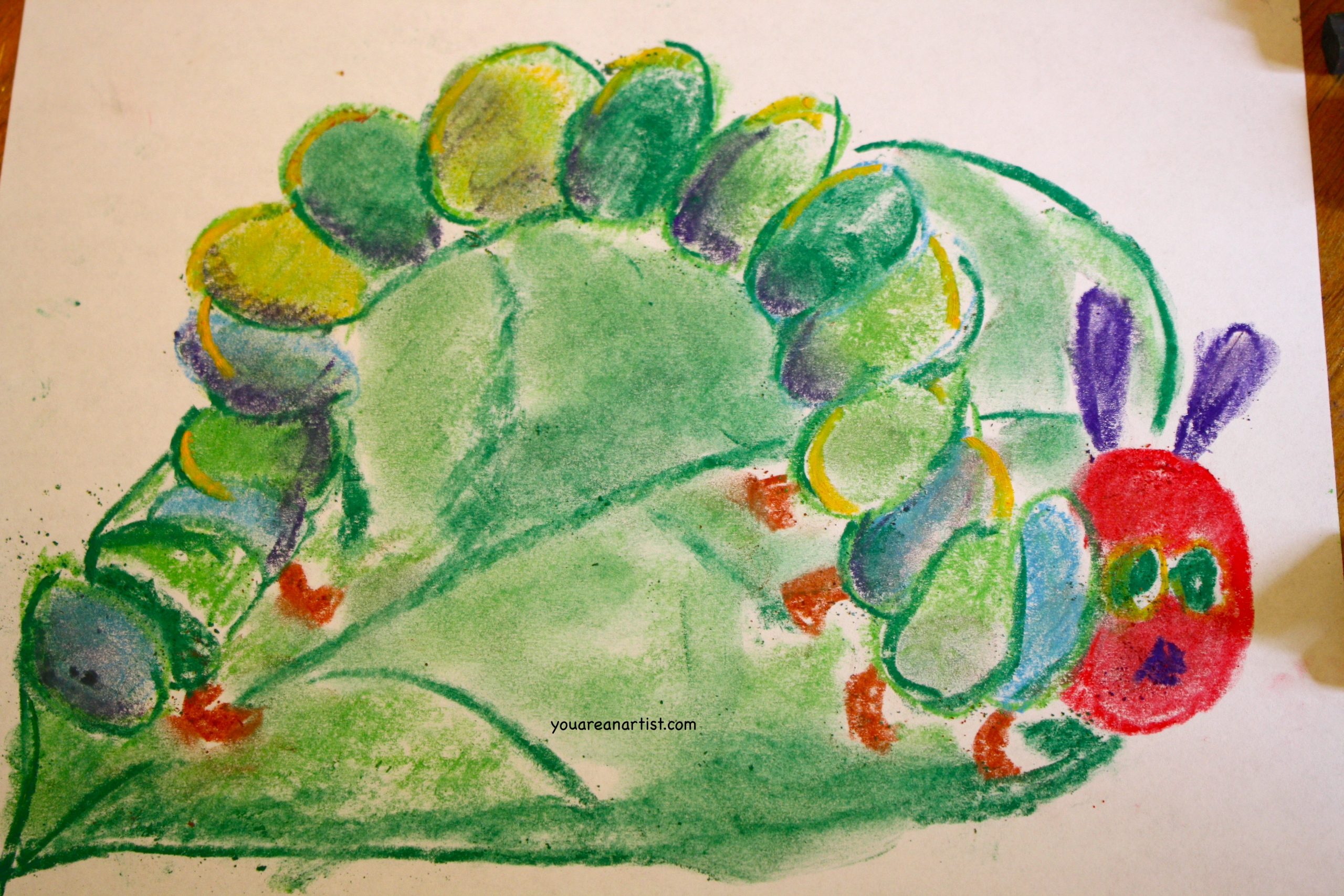 In this art lesson, Nana's granddaughter teaches her how to draw a caterpillar with chalk pastels in the style of Eric Carle's Very Hungry Caterpillar.