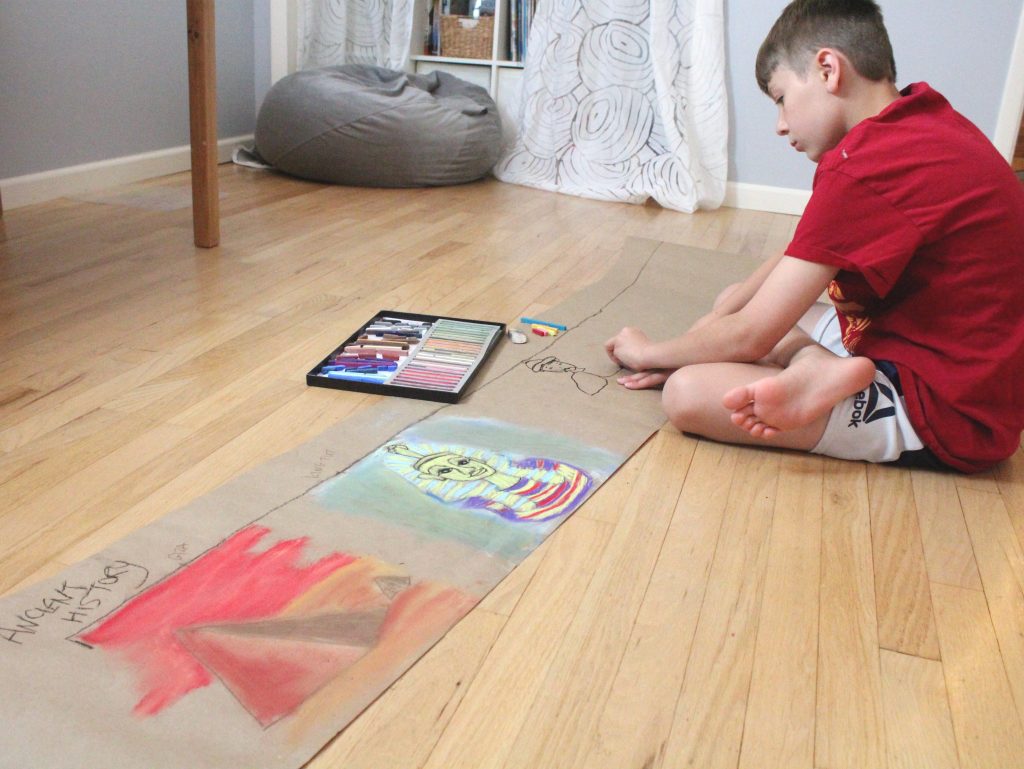 Child drawing on the floor with chalk pastels